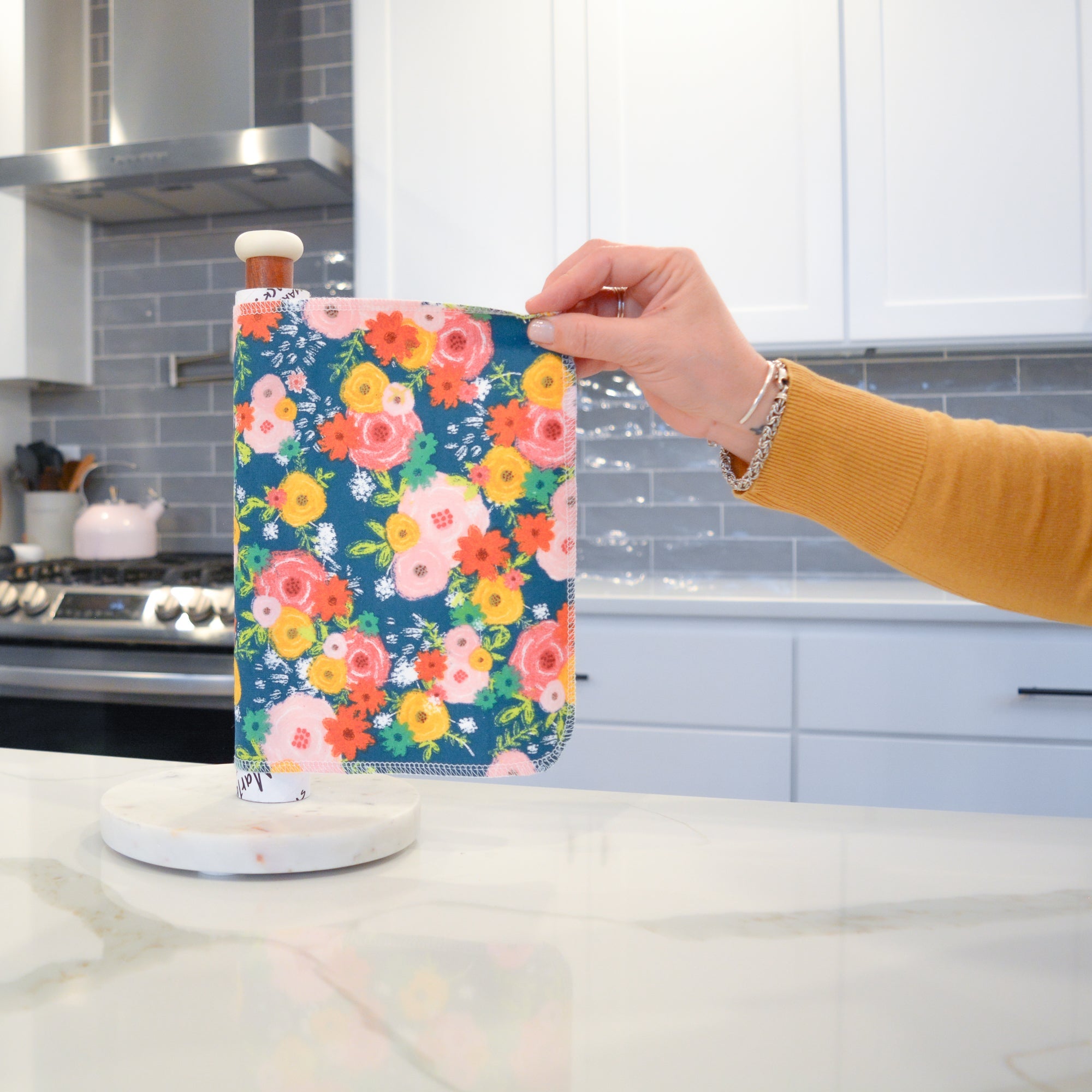 Shows a hand pulling off one UNpaper® Towel in the Marley's Favorites pack in the Fall Floral print. Marley's Monsters