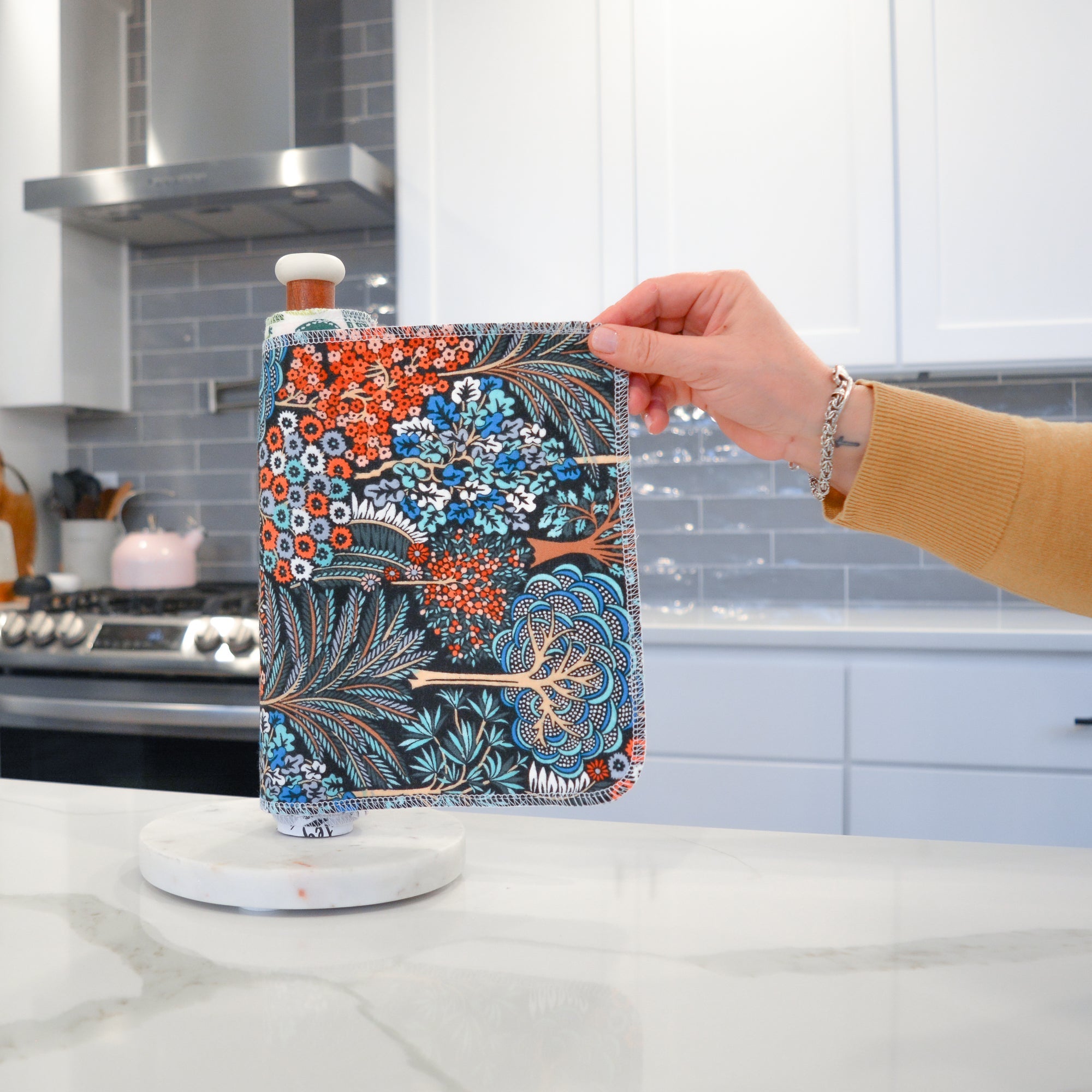 Shows a hand pulling off one UNpaper® Towel in the Marley's Favorites pack in the Packed Trees print. Marley's Monsters