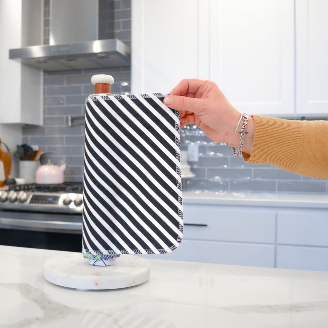 Shows a hand pulling off one UNpaper® Towel in the Marley's Favorites pack in the Medium Stripe print. Marley's Monsters