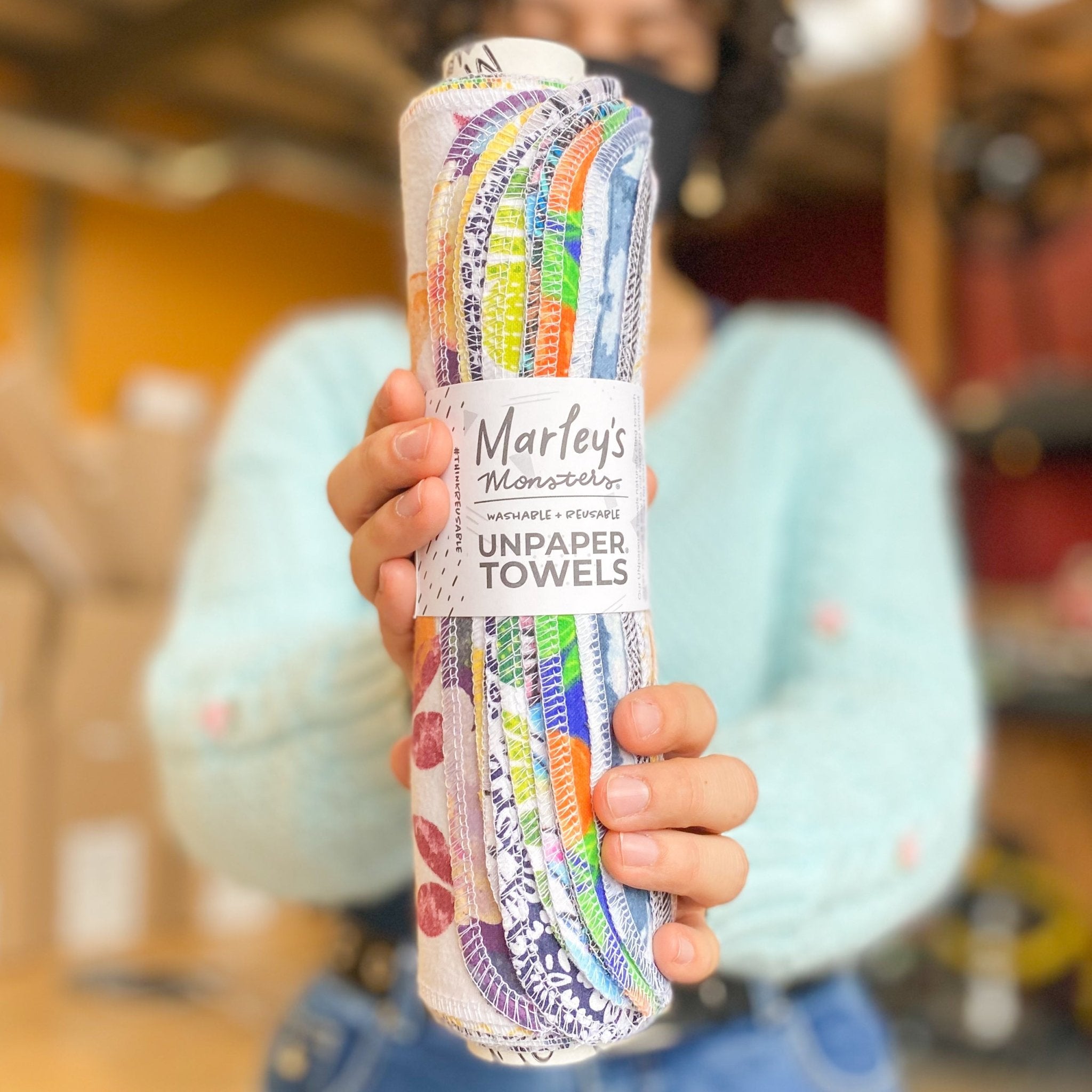 UNpaper® Towels: Marley's Favorites! - Marley's Monsters shows a human blurred in the background holding the roll of towels