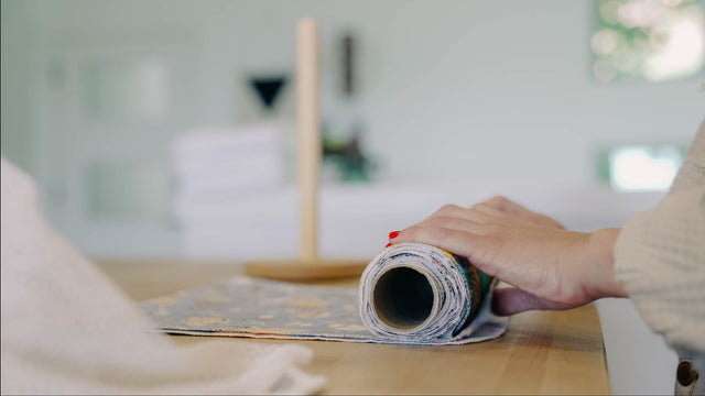 Hands rolling clean UNpaper Towels onto a tube on the counter