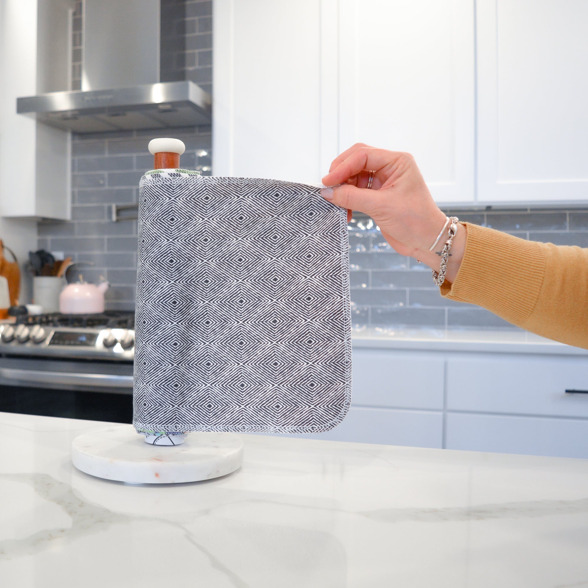 Shows a hand pulling off one UNpaper® Towel in the Marley&#39;s Favorites pack in the Midnight Mosaic print. Marley&#39;s Monsters