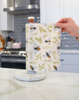 Shows a hand pulling off one UNpaper® Towel in the Marley's Favorites pack in the Bees and Plants print. Marley's Monsters