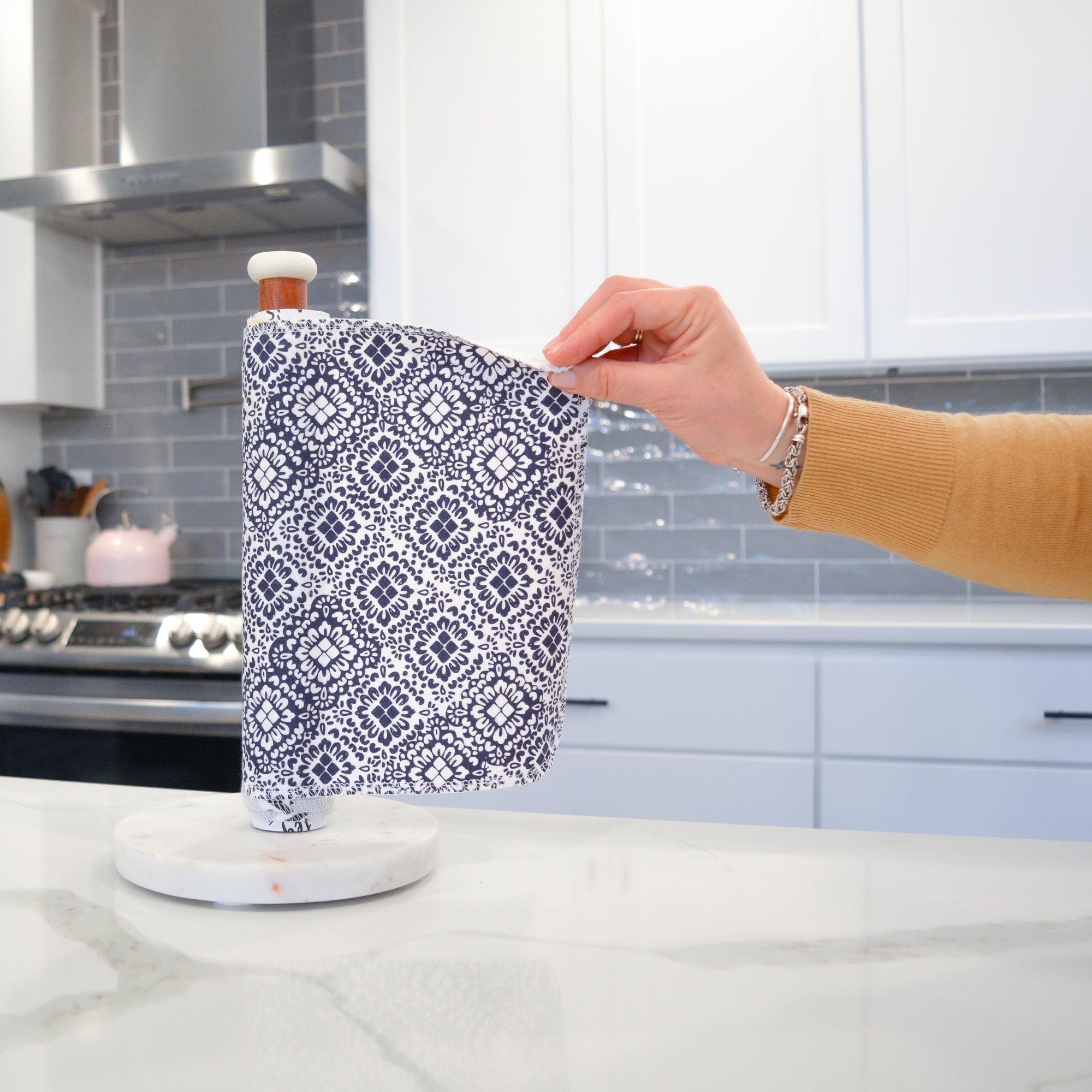 Shows a hand pulling off one UNpaper® Towel in the Marley&#39;s Favorites pack in the Midnight Mosaic print. Marley&#39;s Monsters